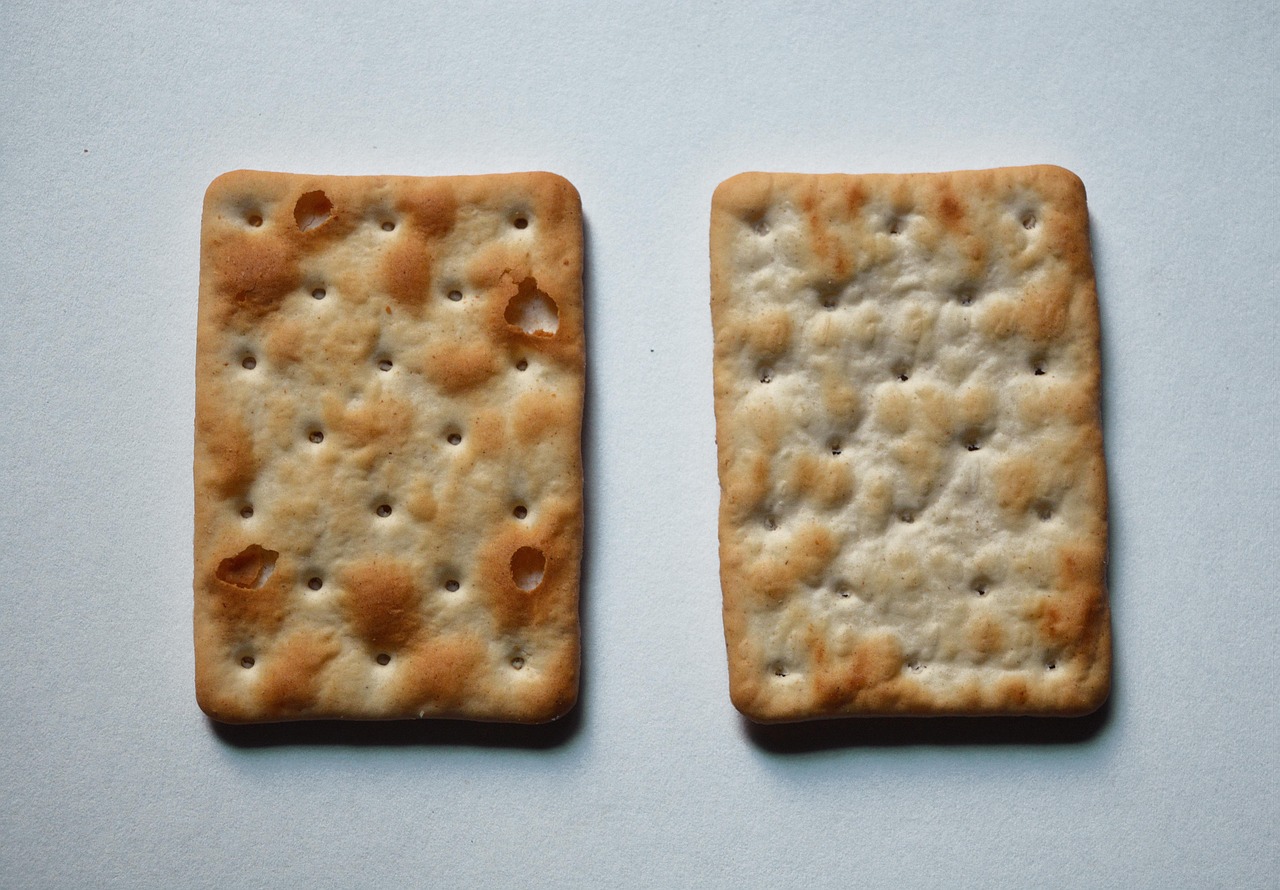 Immagine di diverse confezioni di crackers con etichette che evidenziano ingredienti poco salutari.